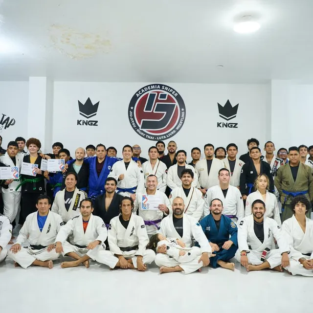Gran foto grupal de todo el equipo de la academia con alumnos sosteniendo certificados al frente