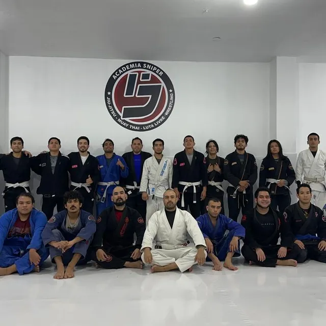 Alumnos posando en dos filas dentro del gimnasio, algunos con kimono y otros con ropa deportiva