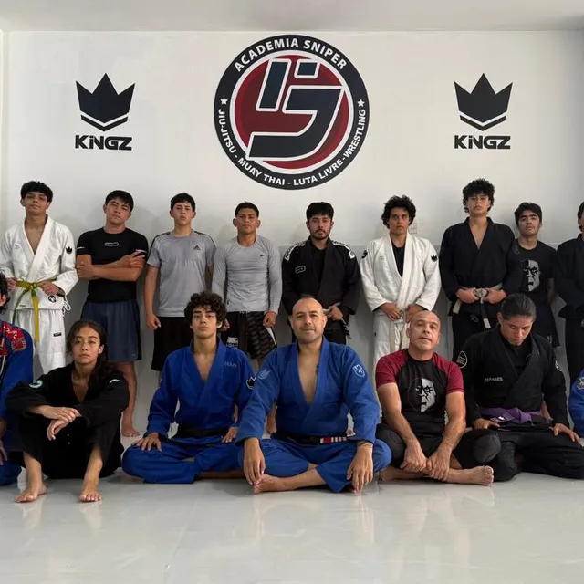 Equipo posando con gis blancos y negros frente a mural de patrocinadores