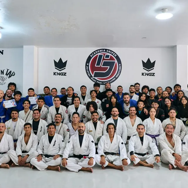 Gran foto grupal del equipo con mural de patrocinadores de fondo